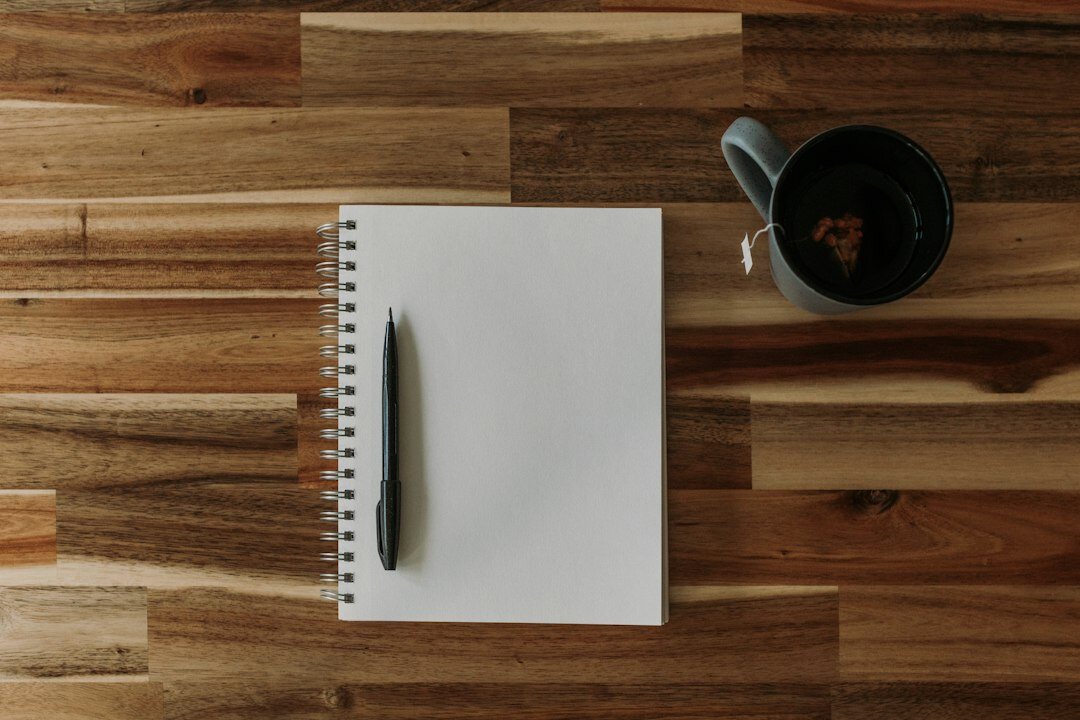Wooden desk with notebook, pen and printed reports